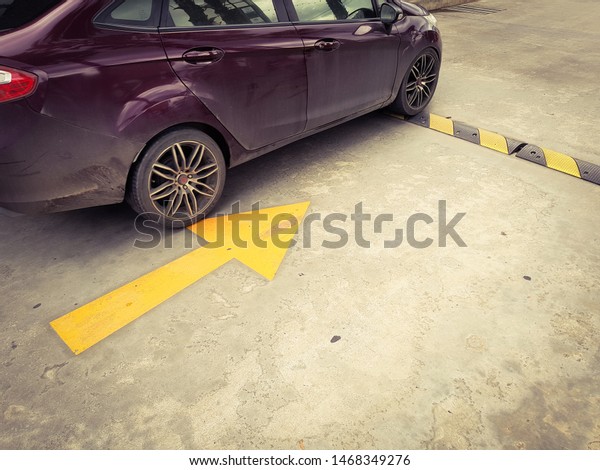 Car on speed\
bumps and yellow arrows on street, traffic signs on concrete\
roadway, vintage style\
pictures.
