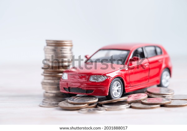 Car on stack of coins. Car loan,\
Finance, saving money, insurance and leasing time\
concepts.