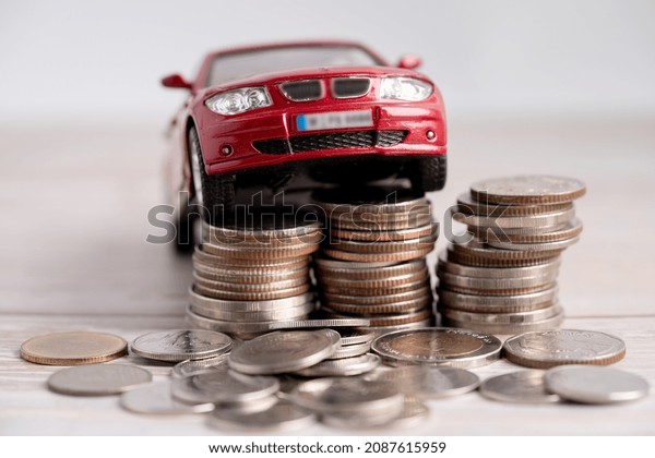 Car on stack of coins. Car loan,\
Finance, saving money, insurance and leasing time\
concepts.