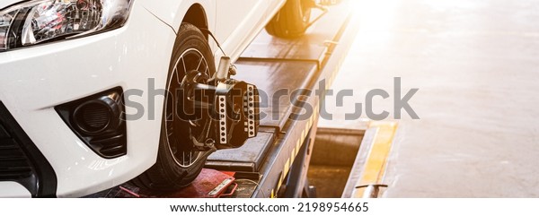 Car on stand with sensors on wheels for\
wheels alignment camber, Car mechanic installing sensor during\
suspension adjustment.