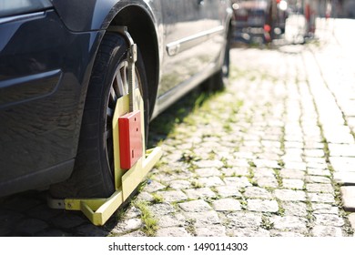 Car On Street With Wheel Clamp, Also Known As Wheel Boot, Parking Boot, Or Denver Boot