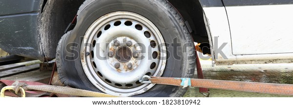 Car is on tow truck with flat tire. Car\
evacuation and transportation\
concept