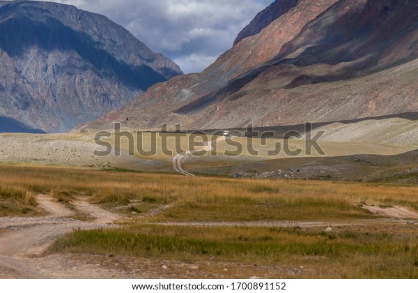Car on winding road. Mongolian landscapes in\
the Altai Mountains, wide\
landscape.