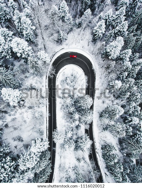 Car on winding\
winter road as seen from\
above