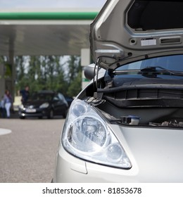 Car With Open Bonnet At A Gas Station