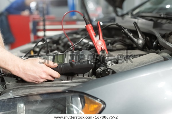 Car, opened bonnet, connect the battery for checking\
close up\
