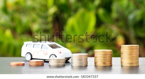 car over a lot of stacked\
coins. declining profits in the automobile and for car\
manufacturers