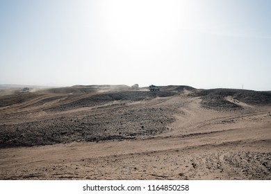 Car Overcome Sand Dunes Obstacles. Competition Racing Challenge Desert. Car Drives Offroad With Clouds Of Dust. Offroad Vehicle Racing Obstacles In Wilderness. Endless Wilderness. Race In Sand Desert.