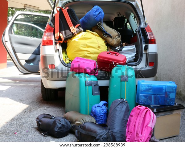 car overloaded with suitcases and duffle bag for\
family travel