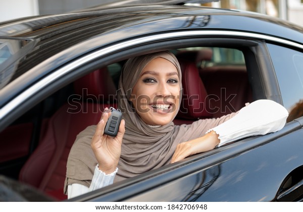 Car\
Owner. Joyful Muslim Woman In Hijab Smiling And Showing Automobile\
Keys Sitting In Her New Vehicle. Confident And Beautiful Lady\
Posing In Driver\'s Seat In Her Luxury\
Transport