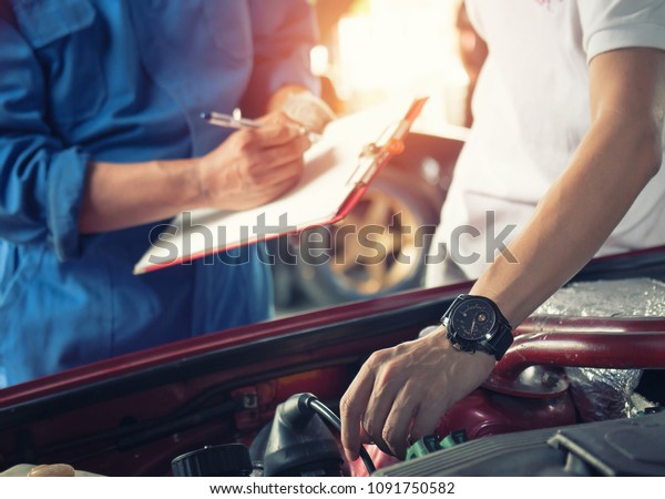 Car owner with car mechanic Check car repair\
machine in the garage.