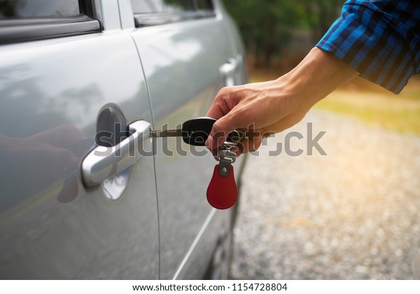 The car owner is\
unlocking the car door.