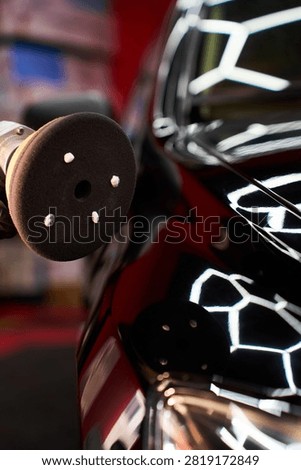 Car paint restoration process features an expert detailer preparing polishing machine with abrasive paste to eliminate swirl marks and bring back deep factory gloss finish..