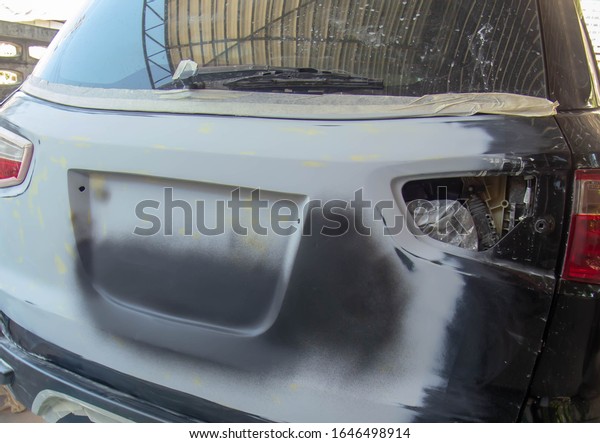 Car paint technician repairing rear door\
car.Selective focus,\
Blurred.