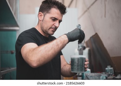 A Car Painter Mixing The Paint To Spray On A Car.