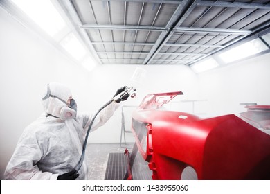 Car Painter Sprays Varnish In Paint Booth.