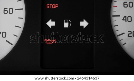               car panel with a lit indicator: emergency oil shortage. stop!                 