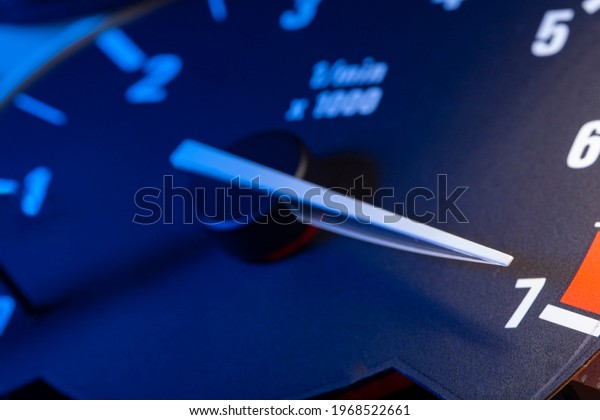 Car panel with tachometer engine\
with White arrow, Close up image of illuminated\
dashboard.