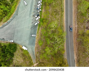 Car Park At Conway Beach Filled With Cars And Boat Trailers After Launching Off The Ramp, With A Truck On The Highway Running Alongside The Precinct