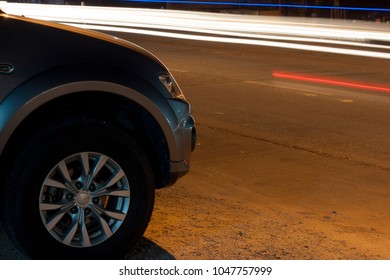 Car Park On Side Road On Night On Front With Motion Of Light Speed From Other Car On The Road.