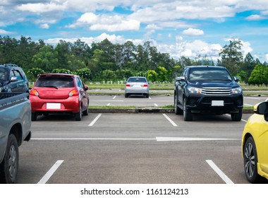 Car Parked In Asphalt Parking Lot And Empty Space Parking  In Nature With Trees, Beautiful Cloudy Sky And Mountain Background .Outdoor Parking Lot With Fresh Ozone And Green Environment Concept
