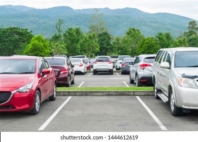 Car parked in asphalt parking lot and empty space parking  in nature with trees and mountain background .Outdoor parking lot with fresh ozone and eco friendly green environment concept - Shutterstock ID 1444612619