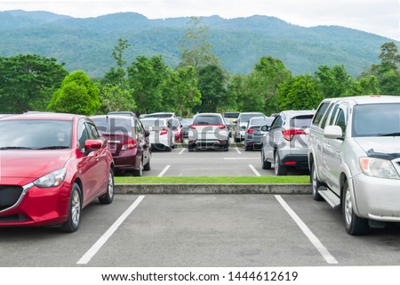 Car parked in asphalt parking lot and empty space parking  in nature with trees and mountain background .Outdoor parking lot with fresh ozone and eco friendly green environment concept