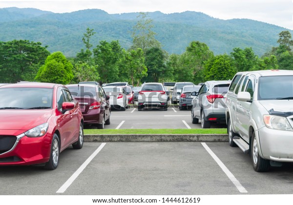 Car\
parked in asphalt parking lot and empty space parking  in nature\
with trees and mountain background .Outdoor parking lot with fresh\
ozone and eco friendly green environment\
concept\
