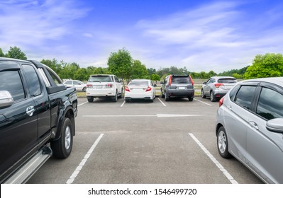 Car Parked In Asphalt Parking Lot, White Cloud And Blue Sky Background, One Empty Space Parking. Outdoor Parking Lot With Fresh  And Green Environment. Travel Transportation Technology Concept
