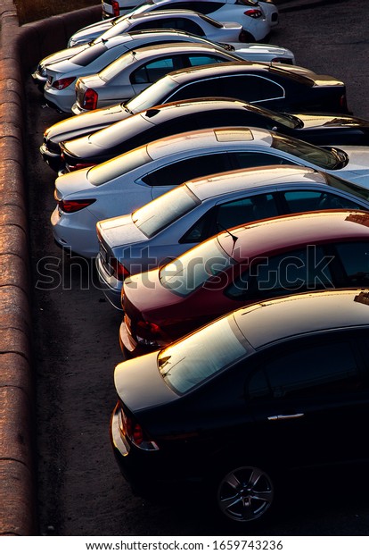 Car parked at concrete parking lot of shopping\
mall in holiday. Aerial view of car parking area of the mall.\
Automotive industry. Automobile parking space. Global automobile\
market concept.