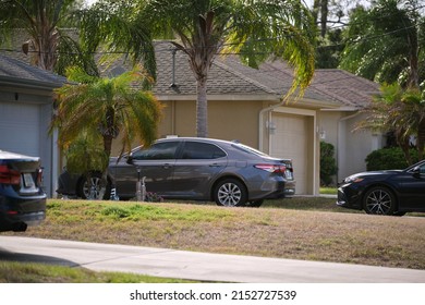 Car Parked In Front Of Wide Garage Double Door On Concrete Driveway Of New Modern American House