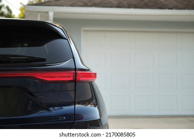 Car Parked In Front Of Wide Garage Double Door On Concrete Driveway Of New Modern American House