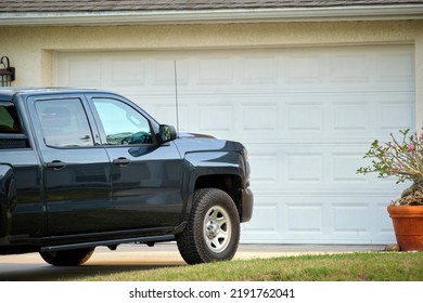 Car Parked In Front Of Wide Garage Double Door On Concrete Driveway Of New Modern American House