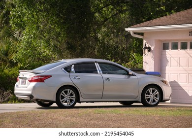 Car Parked In Front Of Wide Garage Double Door On Concrete Driveway Of New Modern American House. Sarasota, USA - May 2, 2022.