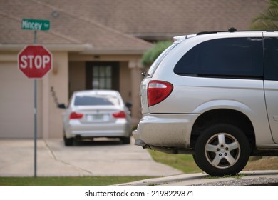 Car Parked In Front Of Wide Garage Double Door On Concrete Driveway Of New Modern American House