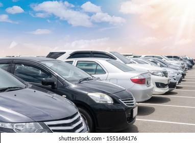 Car Parked In Large Asphalt Parking Lot With Beautiful Cloud And Blue Sky And Sun Background. Outdoor Parking Lot  Travel Transportation Technology With Nature Concept