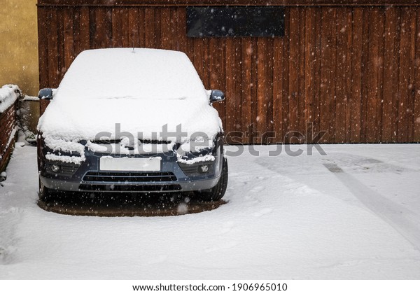 Car parked on british street under winter snow fall\
in england uk.