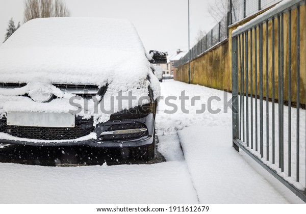 Car parked on british street under winter snow fall in\
england uk