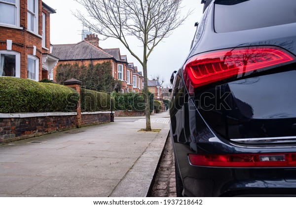 Car parked on\
British street of urban housing\
