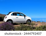 Car parked on the edge of the road, Island La Palma, Canary Islands, Spain, Europe.  
Fiat 500 parked near Rogue de Los Muchachos, at a height of over 2000m. Sea of clouds on the horizon.