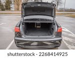 The car is parked with an open trunk. Rear view. Open empty trunk  modern sedan car. The car boot is open and ready for luggage loading. Empty space at the boot of Rental car service.