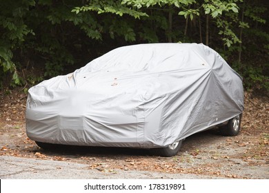 A car parked with a a protective cover.