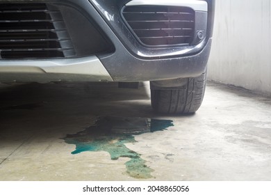 Car Parked With Water Coolant Liquid Leak Out From The Engine Down On The Floor Background