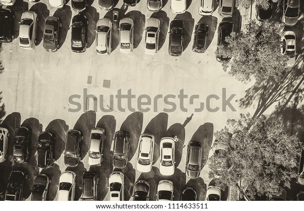 Car\
parking aerial view. Multiple rows of\
vehicles.