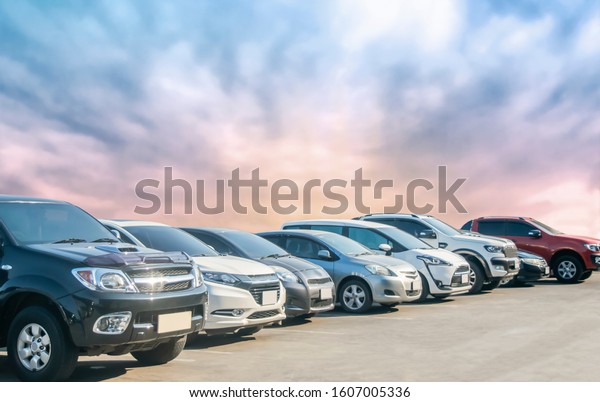 Car parking\
in asphalt parking lot with beautiful sky background. Outdoor\
parking lot with nature fresh ozone and green environment of travel\
transportation business\
concept\
