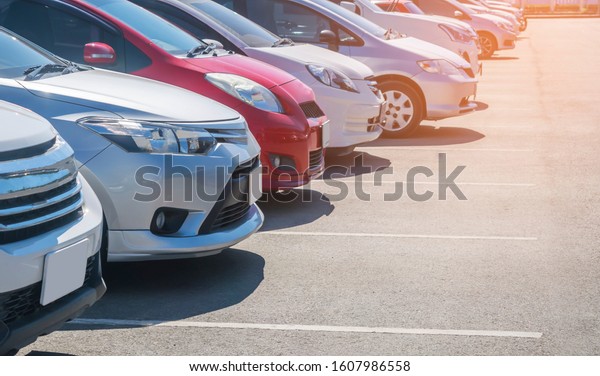 Car\
parking in asphalt parking lot in a row, front of  cars close up,\
automobile transportation dealer business\
concept\
