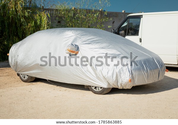 The car is in the parking with auto\
cover from the sun. Protection from heating the\
car.