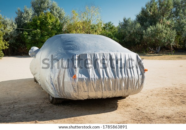 The car is in the parking with auto\
cover from the sun. Protection from heating the\
car.
