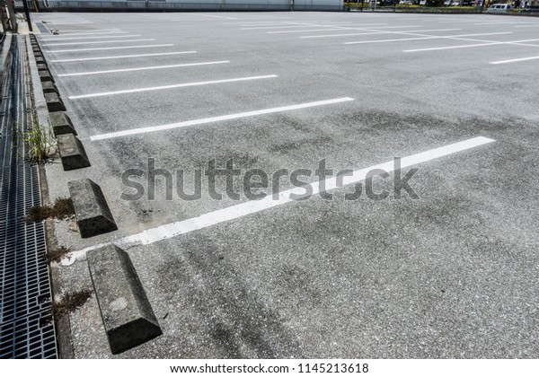 Car Parking lot with parking barrier, White lines\
and car Stopper, Vacant Parking Lot, Parking lane painting on\
floor, copy space