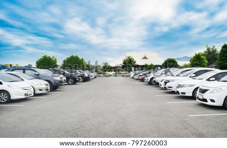 Car parking in large asphalt parking lot with trees, white cloud and blue sky background in front of hall building. Outdoor parking lot with fresh ozone and green environment concept Stockfoto © 